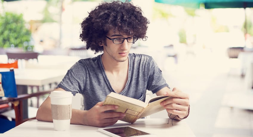 Young man reading book in cafe Young man reading book in cafe