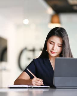 Woman writes in notepad